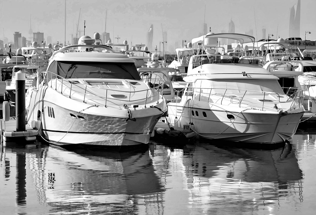 Yachts moored at an upscale marina in the evening light
